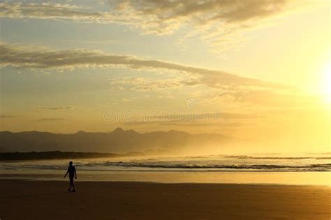 Golden Sunrise Bright Sky And Light Reflection On Water Man Walking