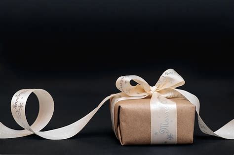 Premium Photo Gift Or Gift Box With A White Bow On A Black Background