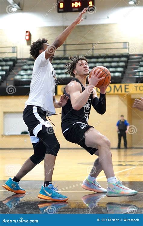 Basketball Player Dribbling The Ball Into The Hoop Editorial