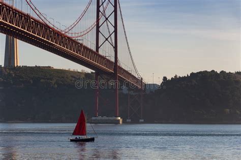 A Small Sailing Boat Passing By The Of April Bridge Ponte De