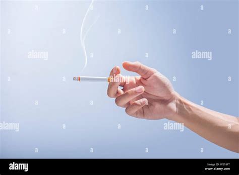 Hand Holding A Cigarette On Gray Background Stock Photo Alamy