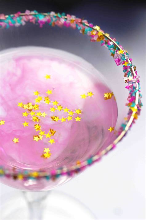 A Pink Cocktail With Gold Stars In It S Rim And Sprinkles On The Rim