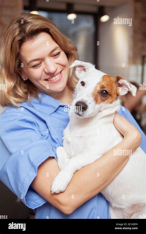 Vertical Portrait Of A Happy Mature Female Veterinarian Hugging