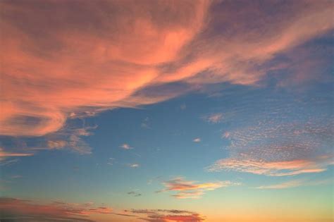 the sun is setting over some water and clouds