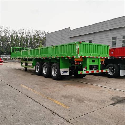 A Green And Red Truck Parked In Front Of A Building