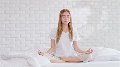 Calm Of Wellness Asian Young Woman Sit On Bed Breathing With Yoga Lotus