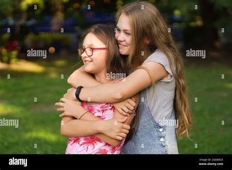 Beautiful Young Woman Hugs Her Younger Sister Love And Friendship