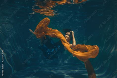 Cute Sporty Female Swims Underwater As A Free Diver In A Blue Evening