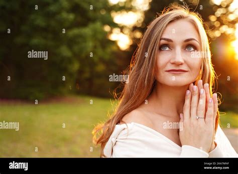 Woman Holds Her Hands In Prayer And Looks Up Beautiful Girl Outdoors