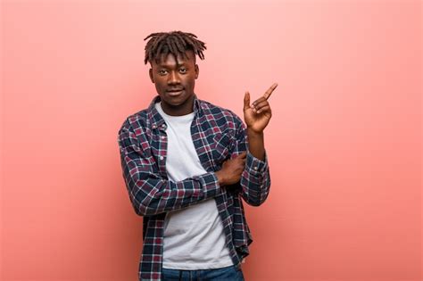 Premium Photo Young African Black Man Smiling Cheerfully Pointing