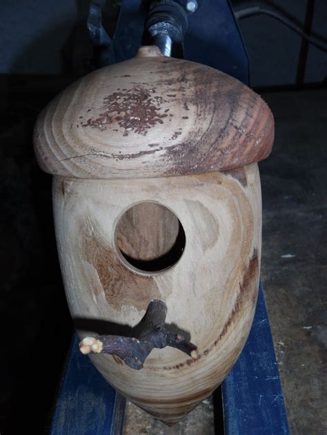 A Wooden Birdhouse Sitting On Top Of A Blue Piece Of Wood