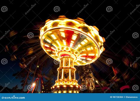 Colorful Chain Swing Carousel In Motion At Amusement Park At Night