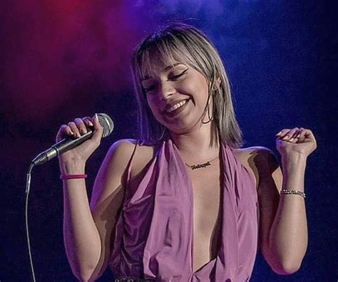 A Woman Singing Into A Microphone On Stage