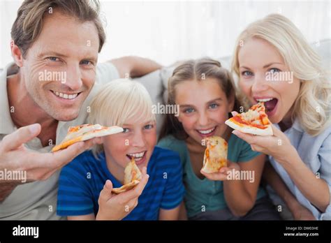 Smiling family eating pizza Stock Photo - Alamy