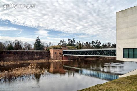 Modern Building Pedestrian Bridge And Historic Defensive Walls Over