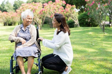 El cuidador ayuda y cuida a una anciana asiática que usa un andador con