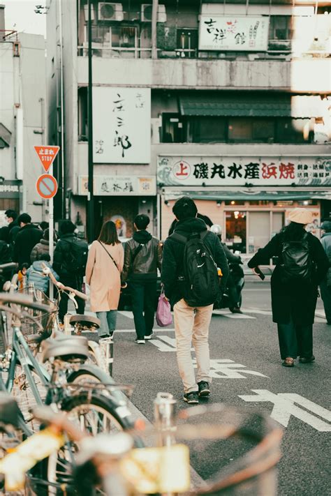 고층 건물 옆 거리를 걷고 있는 한 무리의 사람들 사진 Unsplash의 무료 도쿄 이미지