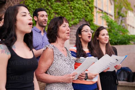 Multi-ethnic choir singers performing outside language school stock photo