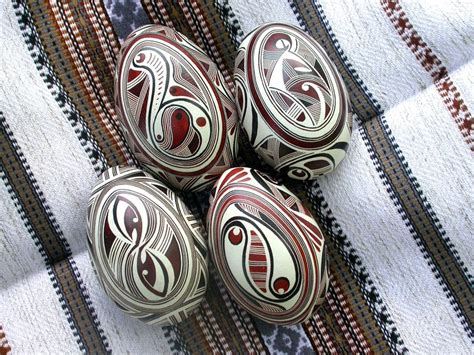 Four Balls With Designs On Them Sitting On A Table Cloth Next To Some