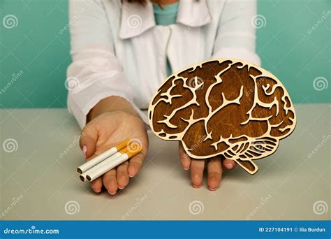 Wooden Model of Brain and Cigarette in the Hands of a Nurse. Smoking ...