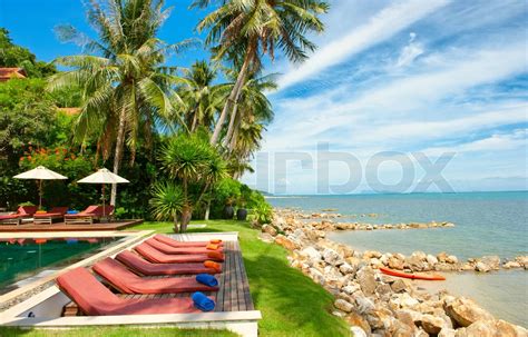 Urlaub Hintergrund Schönes Haus mit Palmen am Strand Stock Bild