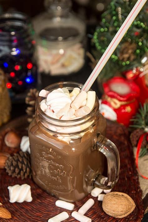 Mug Of Hot Chocolate Drink With Marshmallow Candies On Top And Lights On Christmas Tree And