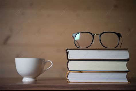 On A Wood Table A Stack Of Books With Glasses And Coffee Cup Photo Background And Picture For