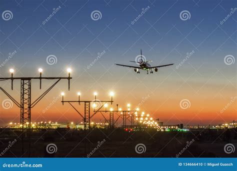 Airplane landing at sunset stock photo. Image of masia - 134666410