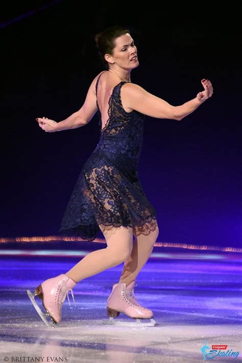 a woman in a blue dress skating on ice