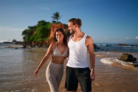 Romantic Couple Strolls On Tropical Beach At Sunset Newlyweds On