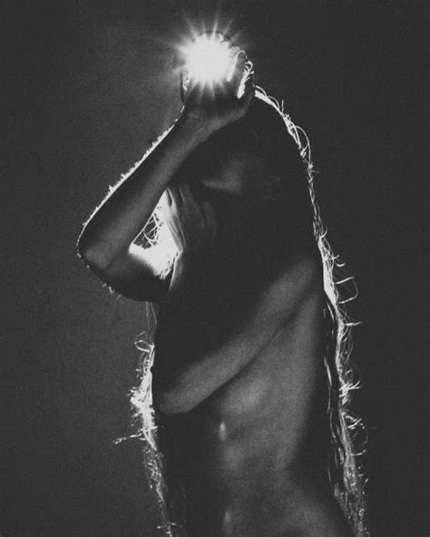 Black And White Photograph Of A Naked Woman Holding A Light Bulb Above