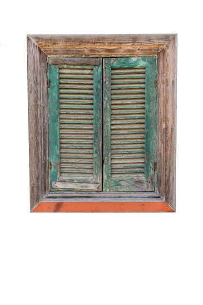 Vieja ventana de madera con persianas de ático verde cerrado vertical