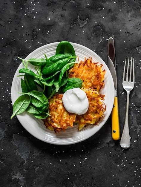 Latkes De Patata Con Crema Agria Y Ensalada De Espinacas En Una Vista