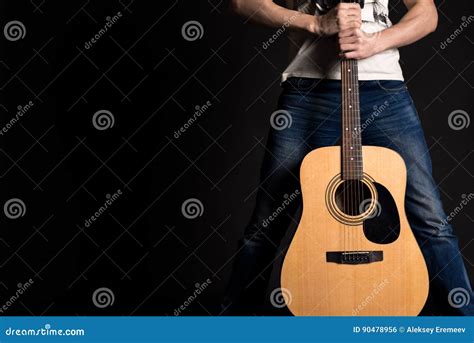 Guitarist Holding Two Hands With An Acoustic Guitar On A Black