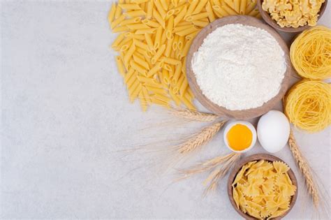 Macarrones Crudos En Cuencos De Madera Con Yema Y Harina Foto Gratis