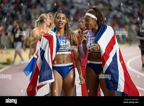 Amber Anning and Nicole Yeargin with her country's flag in the 4x400 meter relay at the World ...