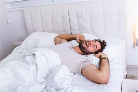 Premium Photo Young Man Sleeping Waking Up And Stretching In His Bed