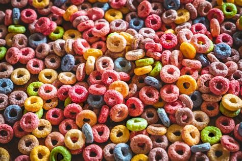 Premium Photo Colorful Round Fruit Cereals Scattered On Brown Wooden