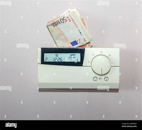 Euro Bills Behind The Thermostat Of The Central Heating System Concept