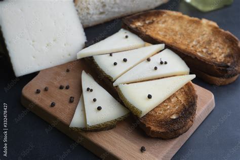 Queso Manchego Sobre Una Rebanada De Pan Tostado Con Algunos Granos De