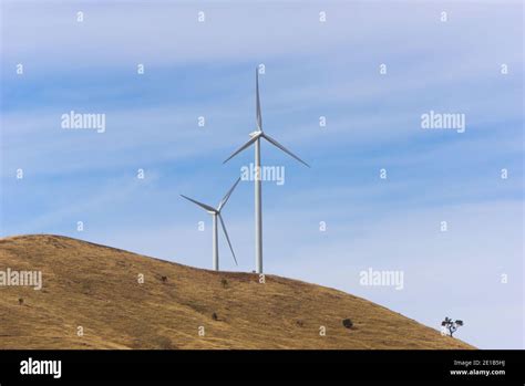 Wind turbine generators on a hillside generating electricity from wind ...