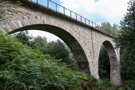 Old Abandoned Stone Railway Arch Bridge Over The River In The Forest