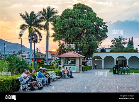 People Enjoy A Beautiful Sunset At Town Center Of Small Town Santa