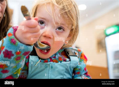 Cute Blonde Girl Eating Beef Noodle Soup In A Restaurant With Her