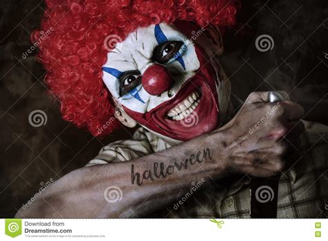 Ond Clown Med Ordallhelgonaaftonen I Hans Arm Arkivfoto Bild Av