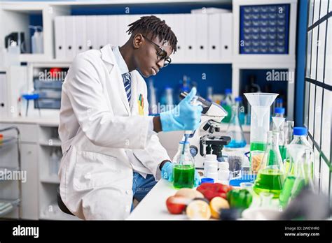 African American Man Scientist Pouring Liquid On Test Tube At