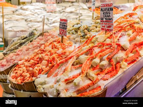 Fishmonger At A Stall With Fresh Seafood Like Crab And Shrimp For Sale