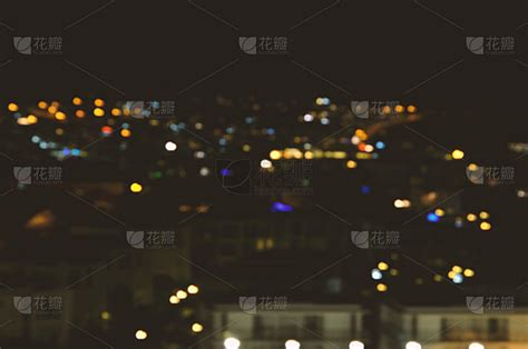 抽象模糊的散景在夜晚的城市背景。——图片