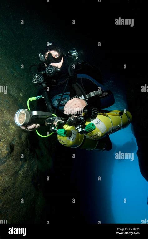 Diver Dives Into Entrance Of Underwater Cave With Special Equipment