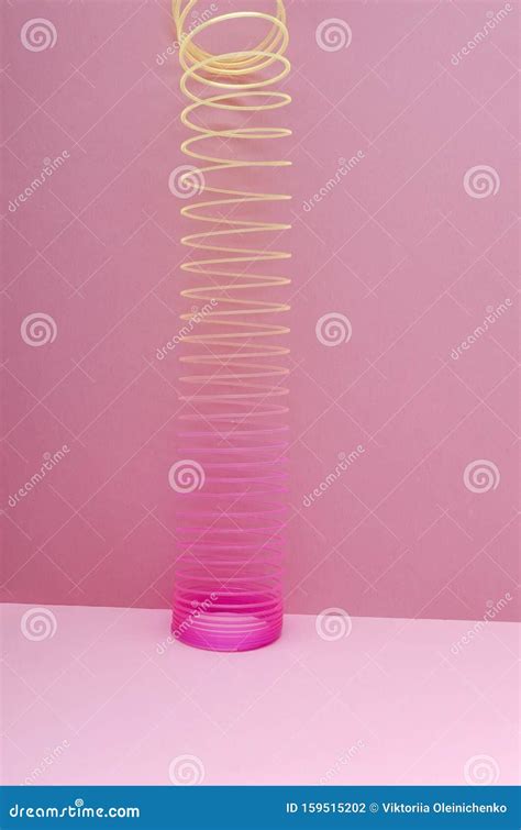 Vertical Shot Of Colored Slinky Toy Against Pink Background Editorial Photography Image Of